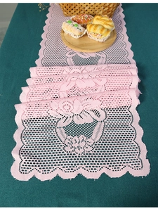 Detail of pink warp-knitted lace table runner featuring heart and geometric hollow patterns
