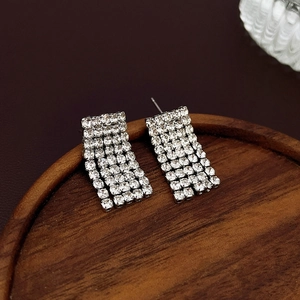 Close-up of rectangular silver earrings with five rows of sparkling cubic zirconia