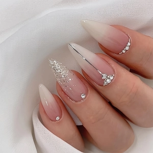Gros plan d'ongles stiletto longs à coller avec paillettes argentées et strass