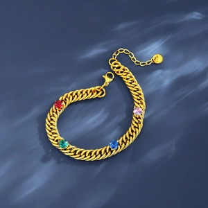 Gold Cuban link bracelet with vibrant colorful zircon gemstones on a blue background