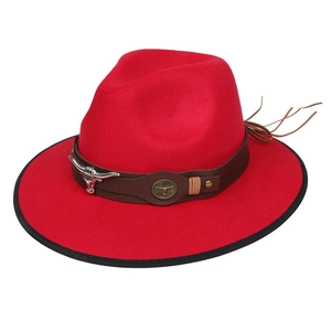 Detail of red cowboy hat featuring a leather band and metal bull head ornament