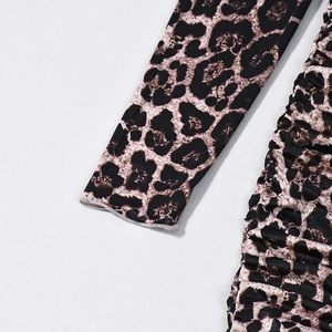 Detailed close-up of leopard print dress fabric with ruching and high-elastic knit texture