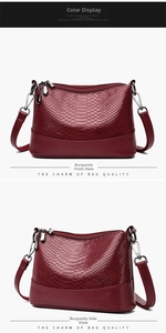 Close-up of wine red embossed texture leather handbag with dual silver zippers and strap