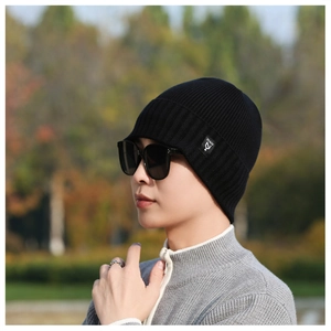Close-up of black ribbed knit beanie with a stylish NY&JA woven label on the side