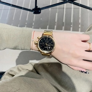 Elegant gold stainless steel watch with black dial and chronograph displayed on wrist