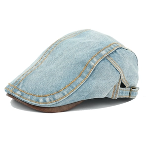 Detail of blue washed denim newsboy cap with brown leather brim and orange stitching