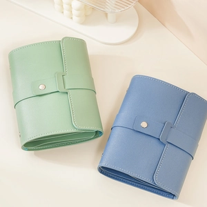 Portable PU leather jewelry organizers in green and blue with metal snap closures