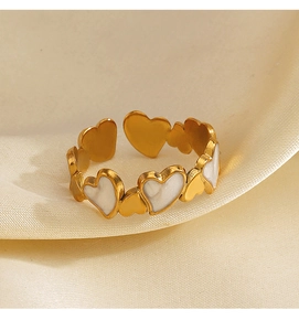 Détail de la bague coeur dorée avec des accents en émail blanc sur soie douce