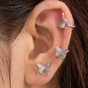 Close-up of a silver butterfly ear cuff set with micro-pave zircons worn on a model