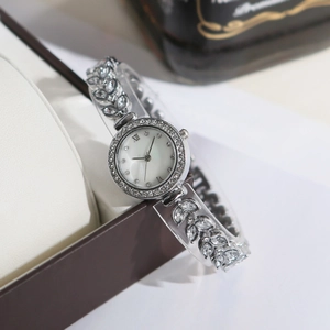 Detail of luxury mermaid bracelet watch with crystal leaf band on beige pillow cushion