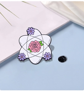 Macro detail of enamel atom brooch featuring pink rose and purple floral design