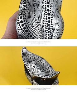 Detail of silver owl sculpture with black polka dots and sleek metallic electroplated finish