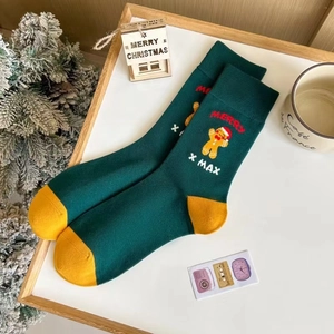 Détail de chaussette de Noël verte avec broderie bonhomme de pain d'épices