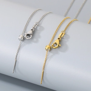 Detailed macro shot of 18k gold and silver needle-style adjustable box chain necklaces