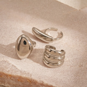 Detailed macro view of minimalist silver geometric rings set on natural stone background