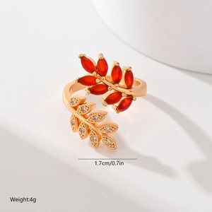 Detail of leaf-shaped gold ring with red oval gem and tiny zircon crystals