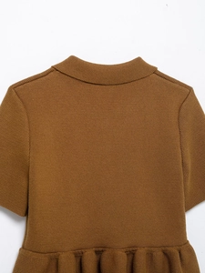 Close-up of brown knit top featuring a high collar, short sleeves, and ruffled hem details