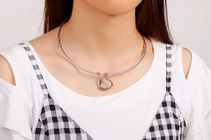 Detail shot of heart pendant necklace with wire choker on model neck in silver