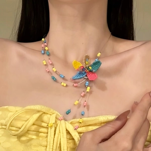 Detailed view of a colorful dopamine glass beaded flower necklace worn on model.