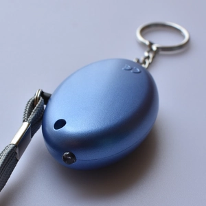 Detailed macro view of the CE certification logo and LED light on blue personal alarm