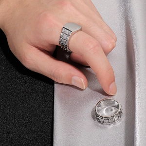 Detailed view of silver stainless steel biker rings with textured and signet designs