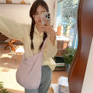 Selfie miroir montrant un sac bandoulière moyen en toile à carreaux violets et blancs