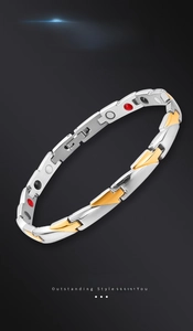 Detail view of titanium steel magnetic therapy bracelet with gold-silver links and red stones