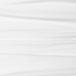 Close-up of premium white textile fabric showing fine weave texture and soft drapes
