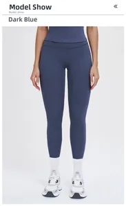 Front view of high waisted yoga pants in dark teal blue color on studio model