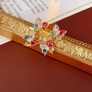 Detail of butterfly earrings with colorful zircons on a vintage gold frame