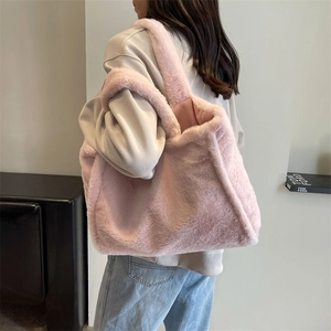 Grand sac cabas en peluche rose à texture douce présenté sur l'épaule du mannequin