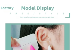 Detail of pink and white chunky teardrop earrings worn by a model in a close-up shot