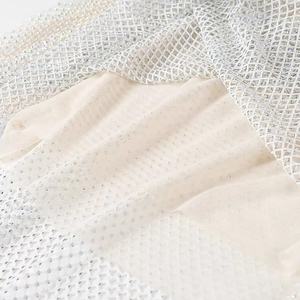 Détail du tissu en maille blanche avec strass brillants sur doublure beige
