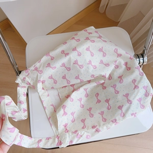 Détail du sac bandoulière léger en coton avec imprimé nœuds roses sur tissu blanc