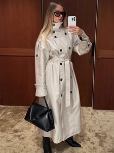 Close-up of stylish double-breasted trench coat with waist belt and lapel collar