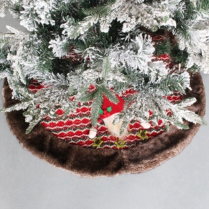 Red knit Christmas tree skirt with festive snowflake patterns and brown plush border