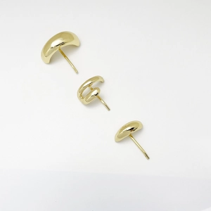 Detailed view of minimalist gold alloy stud earrings set with polished smooth finish