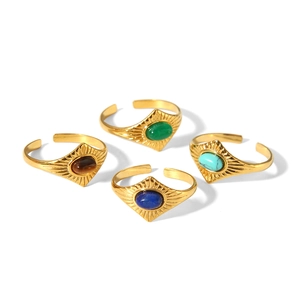 Vue détaillée de quatre bagues vintage dorées serties d'émeraude, turquoise et lapis