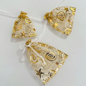 Detail of white organza drawstring gift bags with gold star and spiral foil patterns