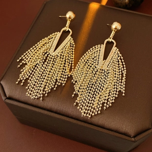 Close-up of elegant gold tassel earrings featuring metallic bead chains and a ball stud