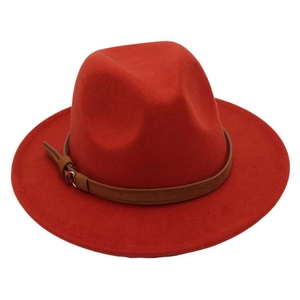 Detail of red fedora hat featuring a brown leather band and gold metal buckle accessory