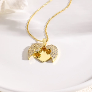 Elegant gold heart locket necklace with sparkling white crystals on a white ceramic plate