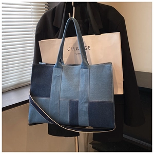 Detail of patchwork denim tote bag featuring adjustable shoulder strap and large capacity