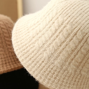 Close-up of thick cable knit texture on a soft mohair bucket hat in multiple colors