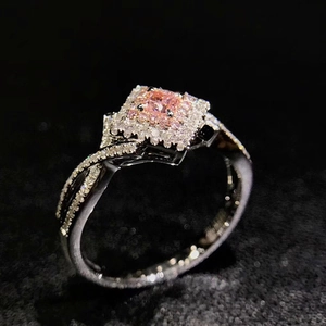 Macro shot of crisscross ring featuring a pink square zircon and micro-pave setting