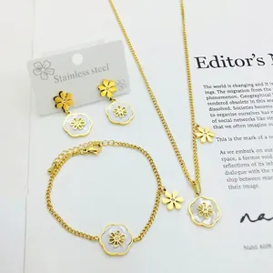 Elegant gold stainless steel jewelry set featuring white daisy pendants and small rhinestones
