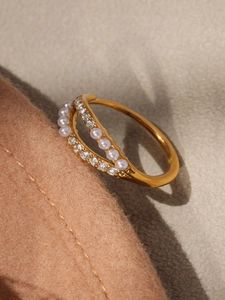 Detailed macro view of gold plated double-layer ring with pearls and pavé cubic zirconia