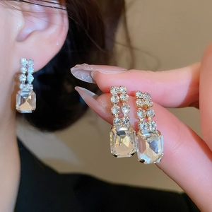 Detail showing vintage gold square diamond drop earrings with sparkling rhinestones set