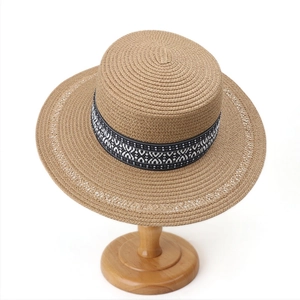 Detailed texture of hand-woven straw hat with black white geometric band and hollow edge