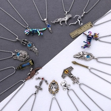 Vue à plat de divers pendentifs hip-hop en argent incluant dinosaures et hiboux avec règle